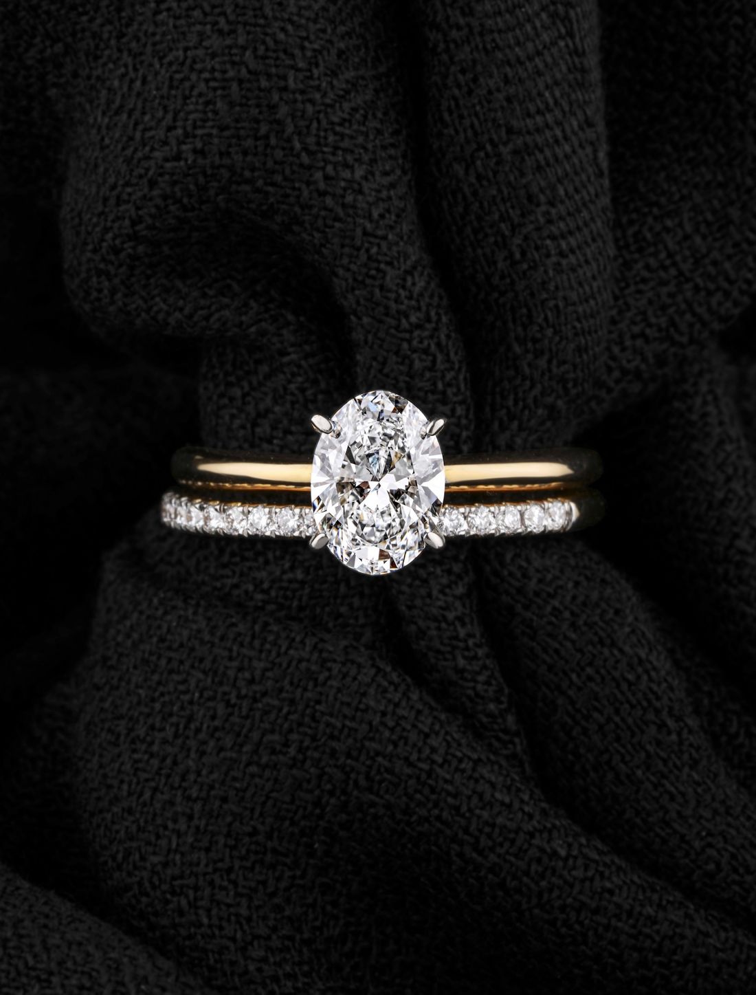 Anel solitário com diamante oval sobre tecido preto